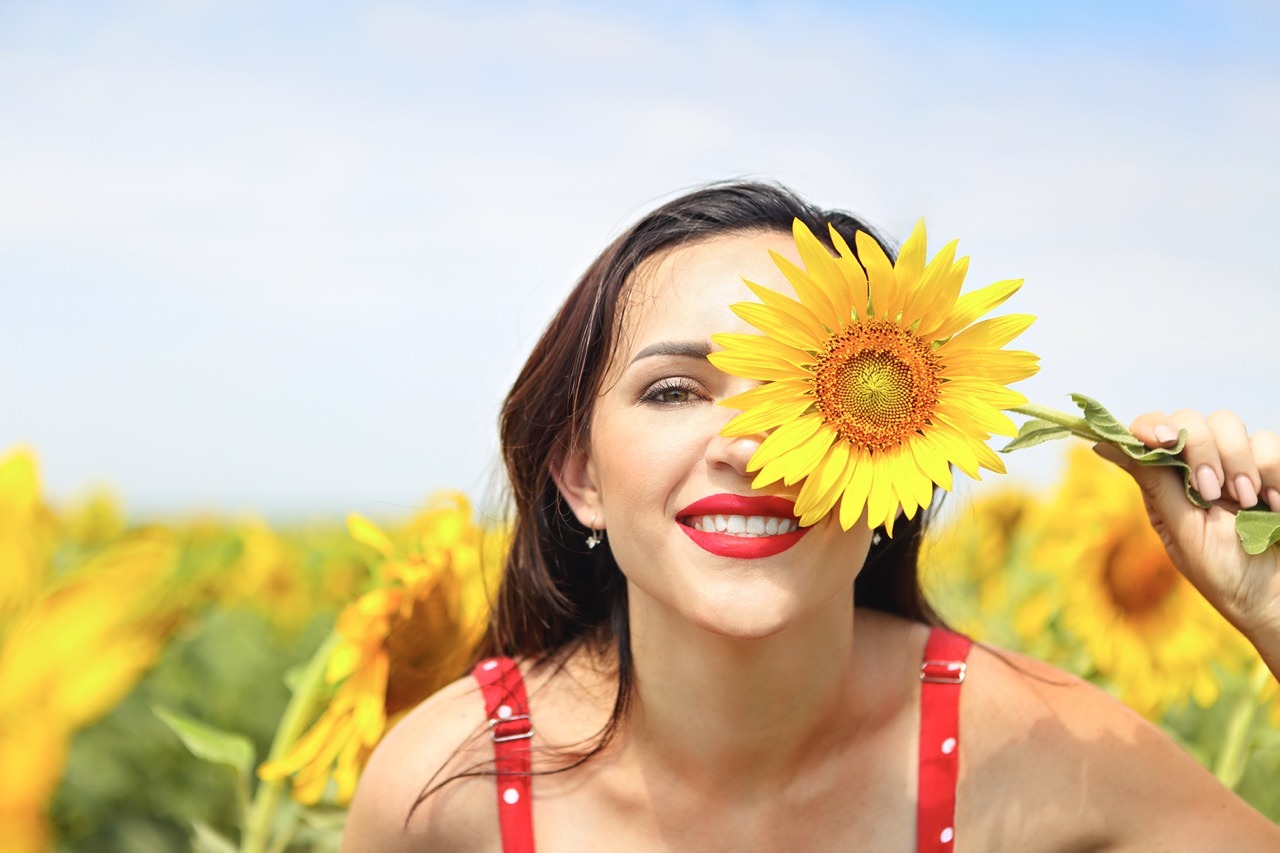 Hübsche brünette Frau im Sonnenblumenfeld